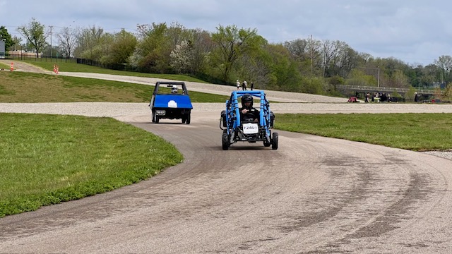 two electric vehicles driving a dirt road
