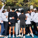 high school boys huddle on the tennis court